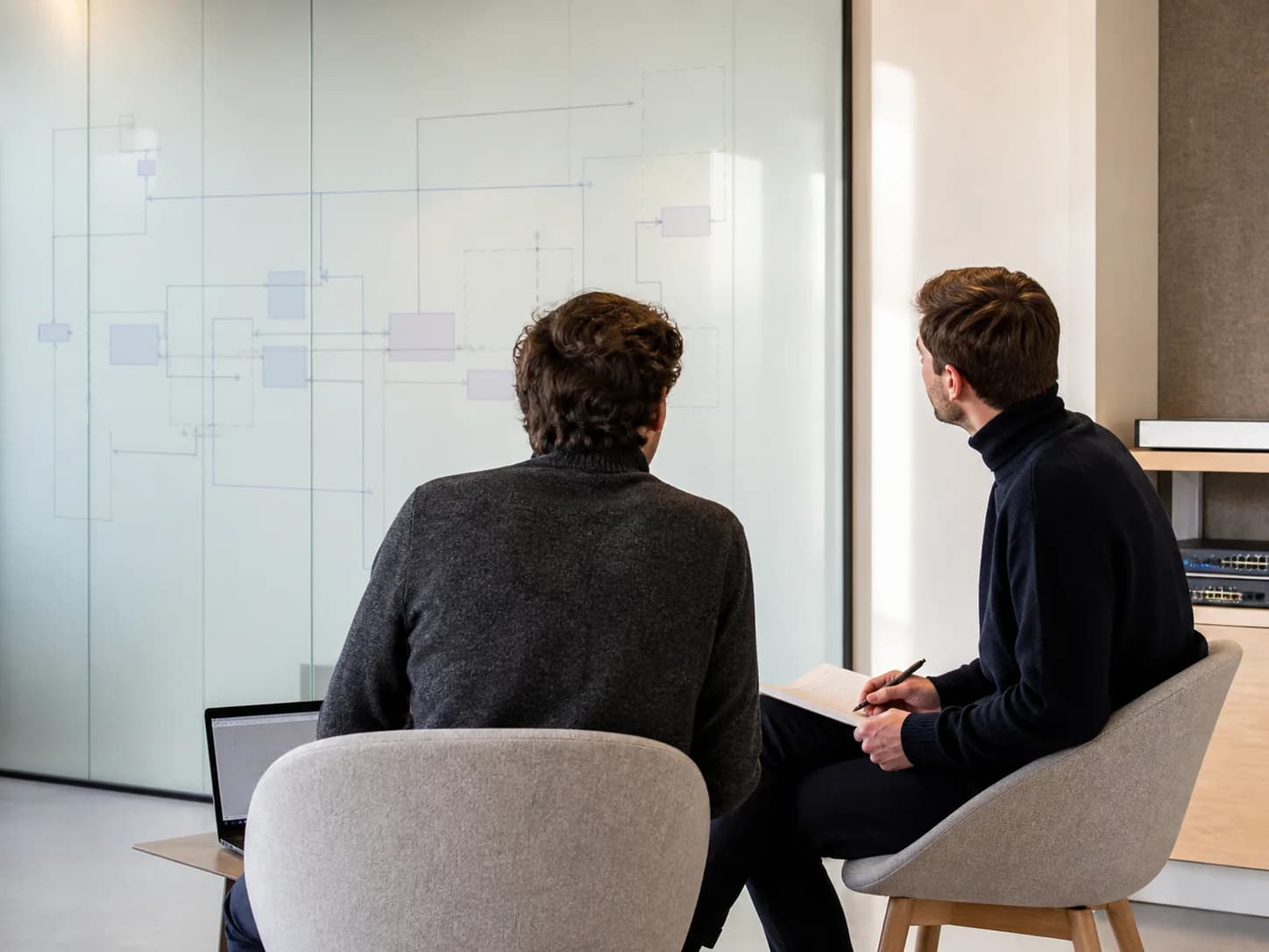Symbolische Darstellung einer gemeinsamen Systemplanung vor einem Architekturdiagramm